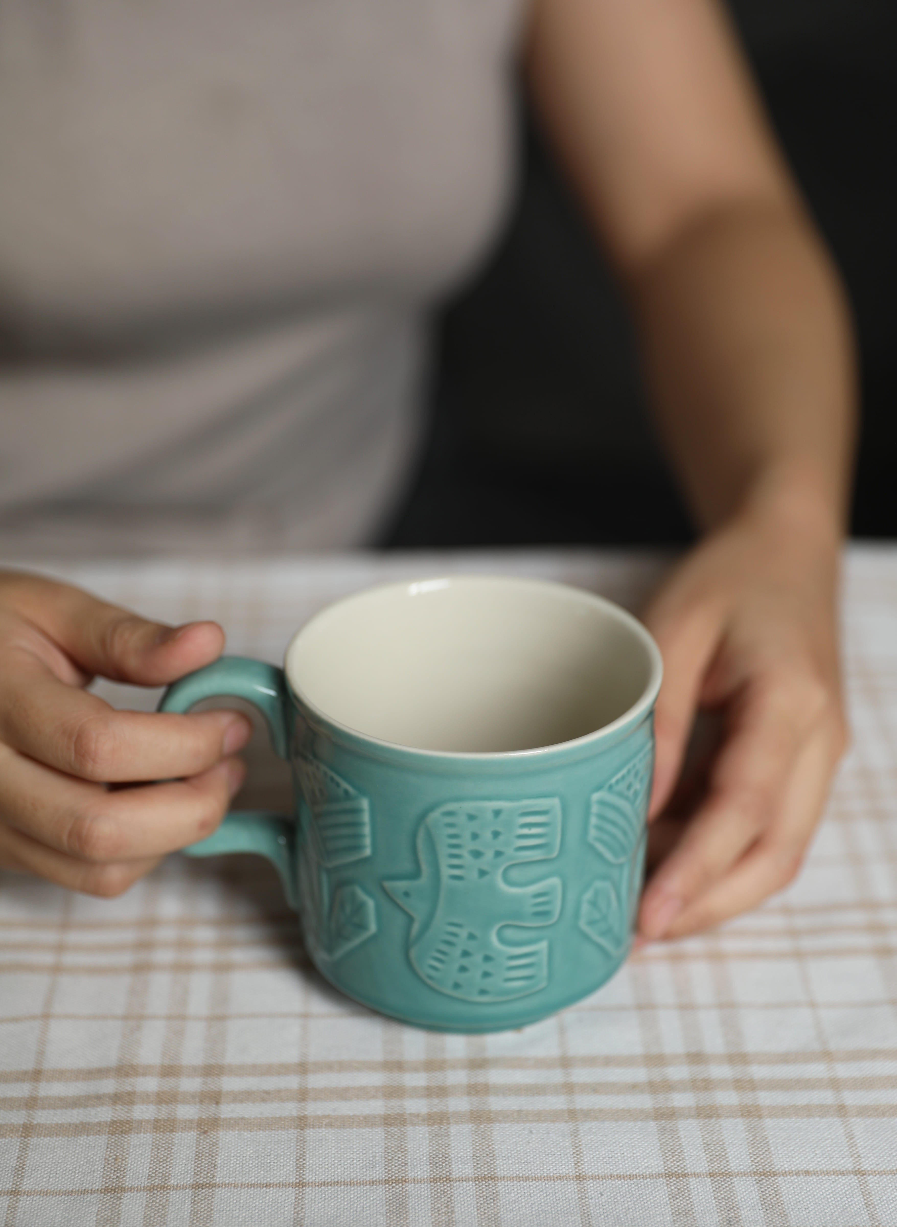 High fired stoneware mug with embossed forest animal motif and warm vintage glaze