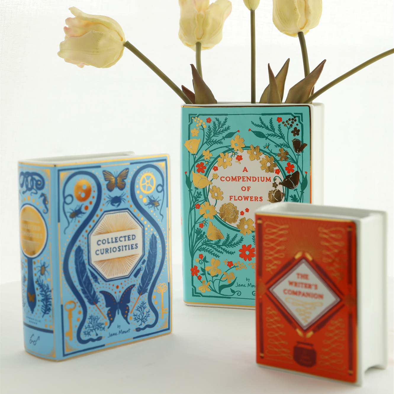 Ceramic vase shaped like a stack of old library books with gold-edged spines