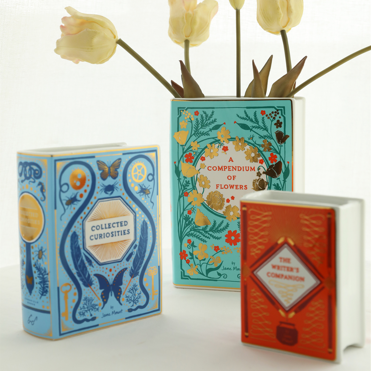 Ceramic vase shaped like a stack of old library books with gold-edged spines