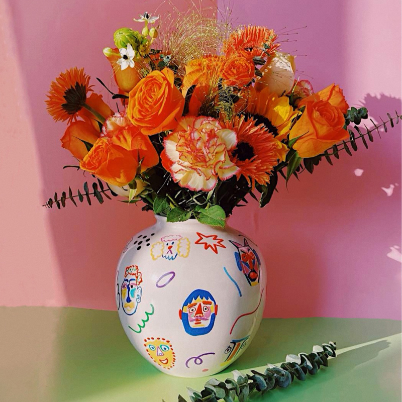 Ceramic vase hand-painted with a carnival of faces