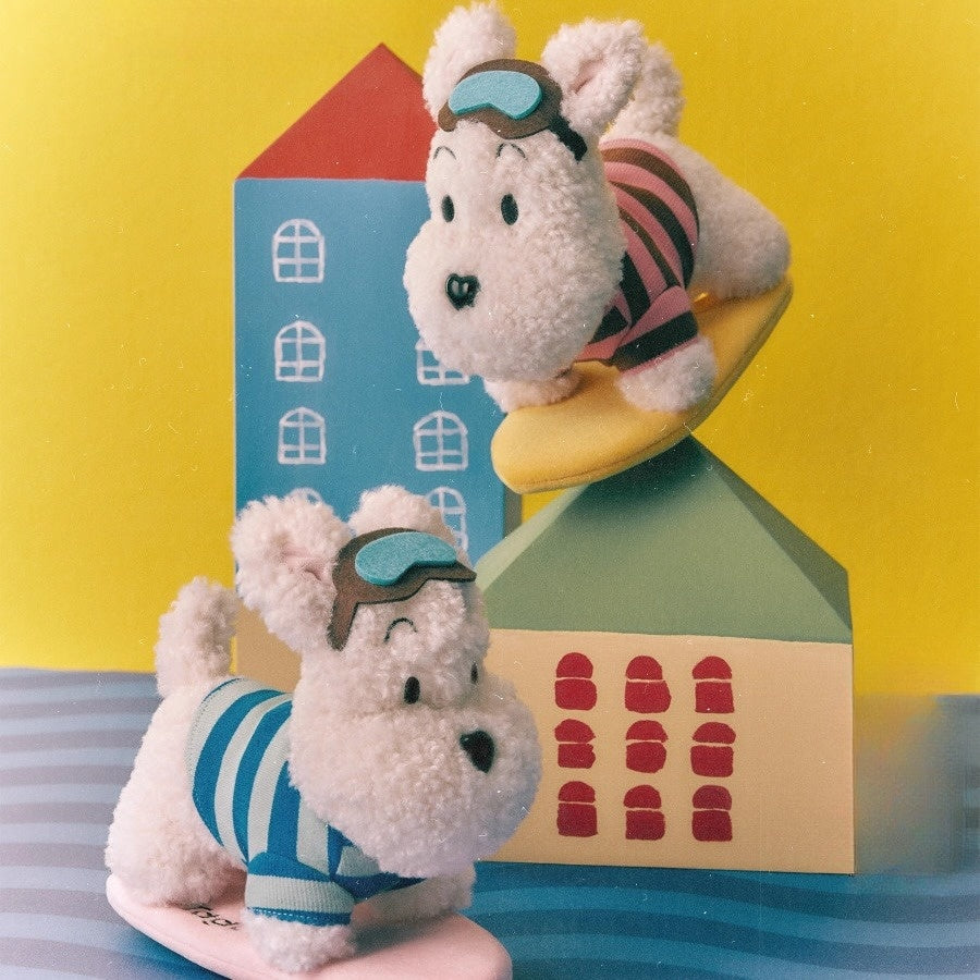 Plush puppy in a soft striped wetsuit, perched on its own surfboard