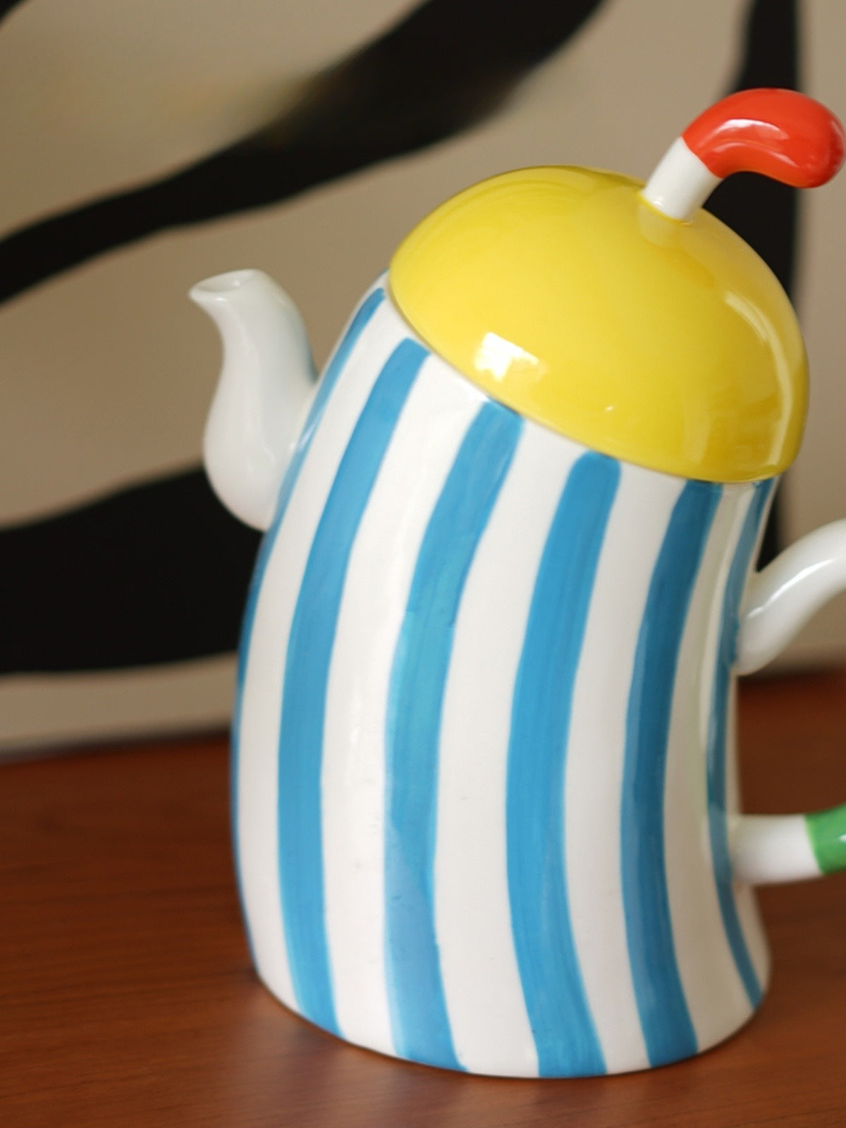 Sculptural striped porcelain teapot with hands on hips, frozen mid-pose