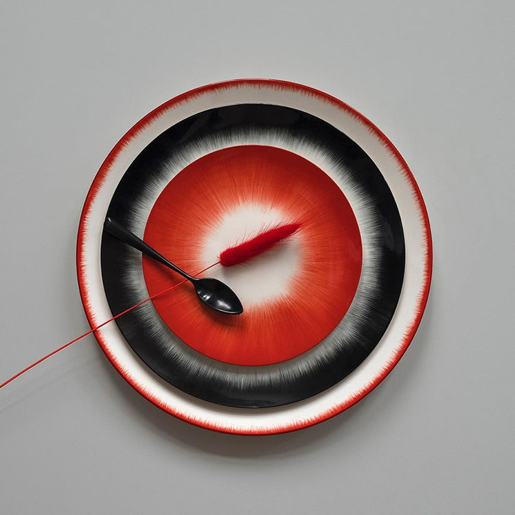Porcelain plates with scarlet brushstrokes spiraling from center to edge