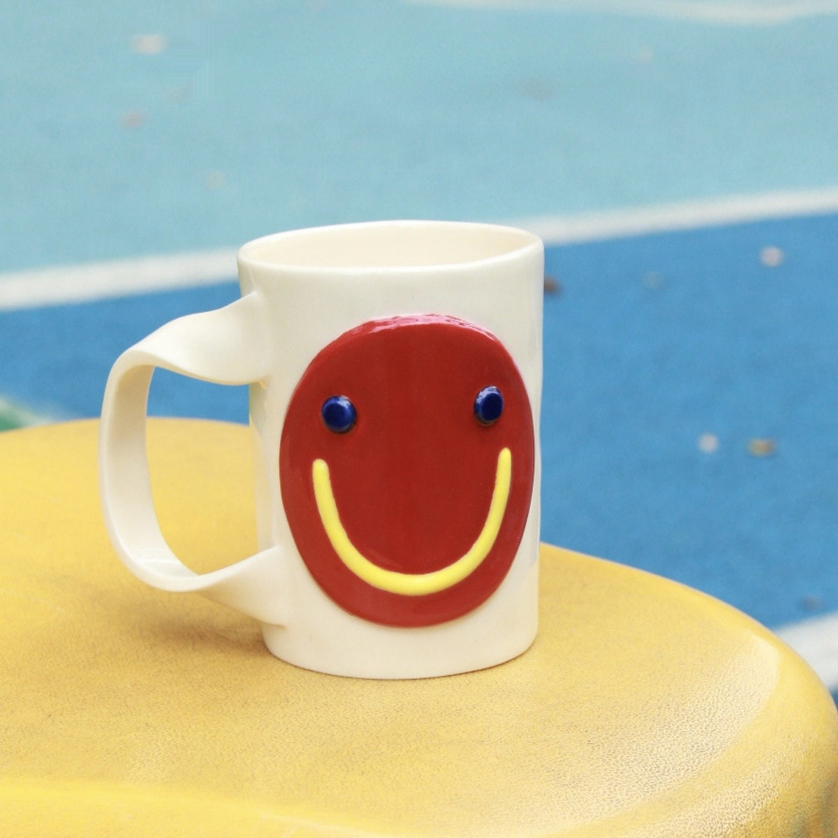 Hand-crafted ceramic mug with a playful 3D smiley face