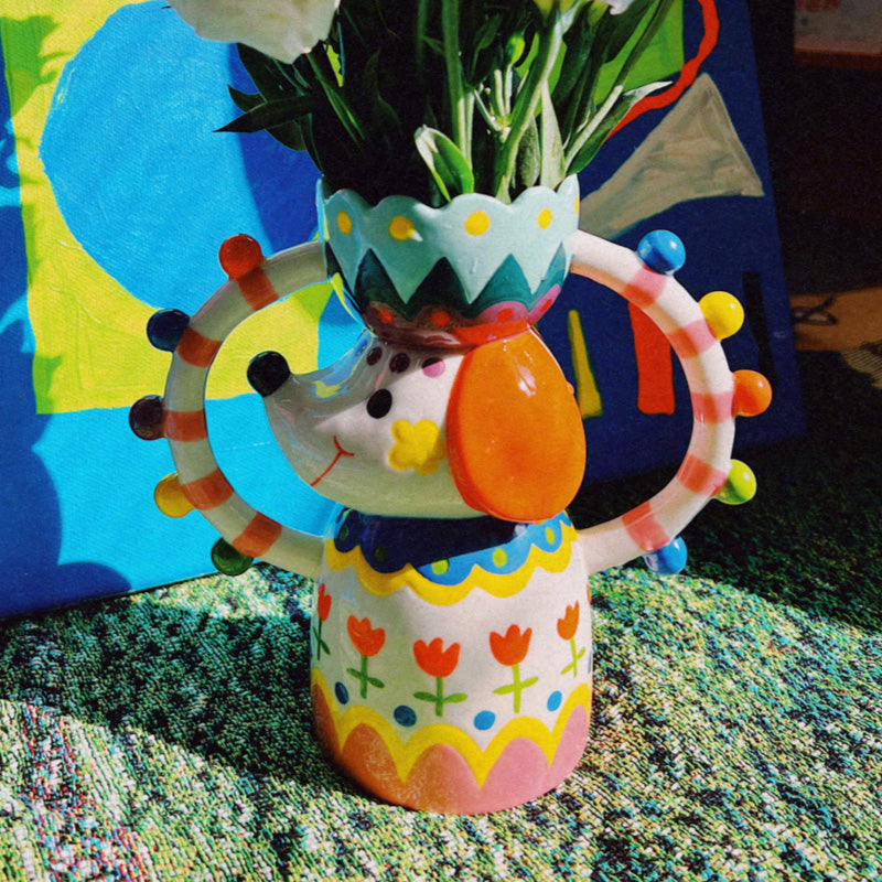 Hand-painted ceramic dog vase bursting with fairground color