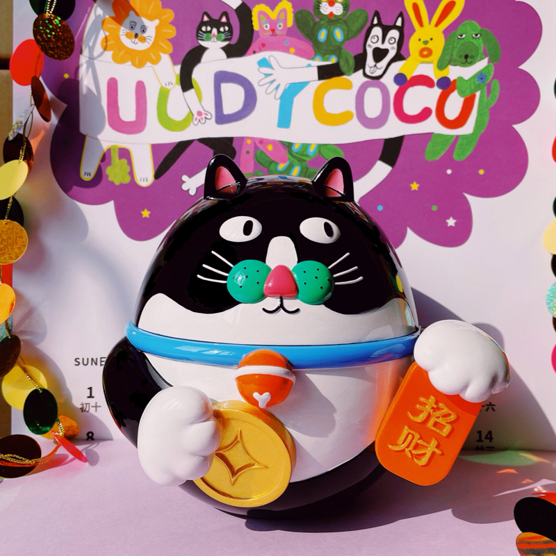 Ceramic lucky cat trinket box with a round belly, candy-colored whiskers and a flower-topped lid