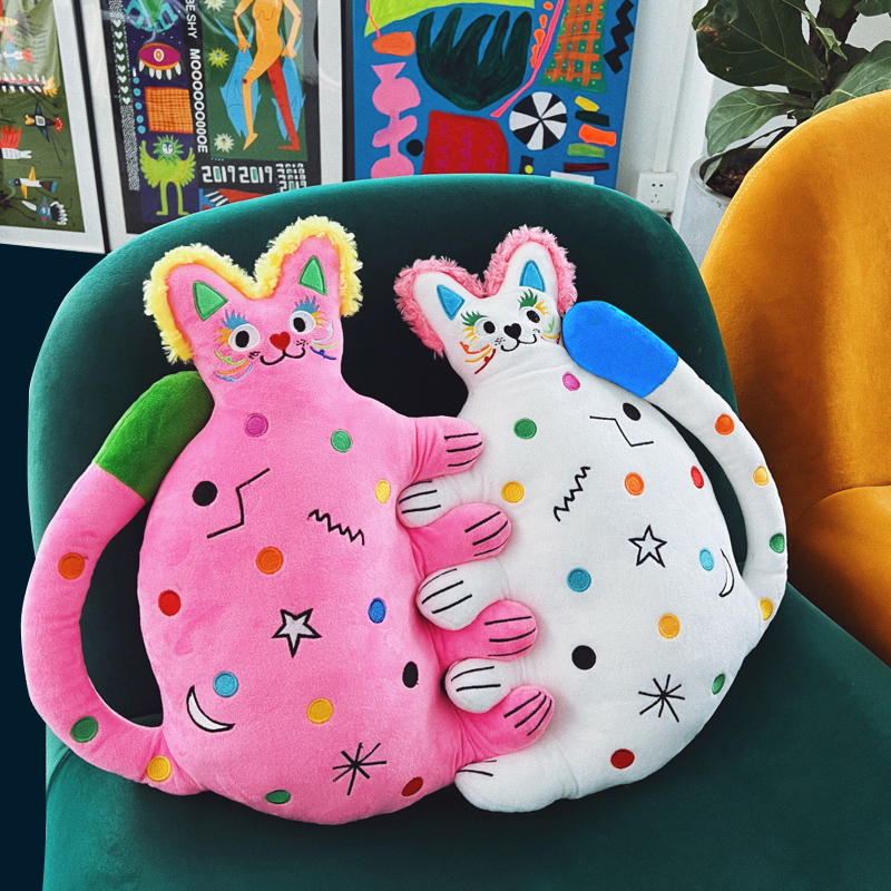 Round confetti-dotted cat plush with radiant charm