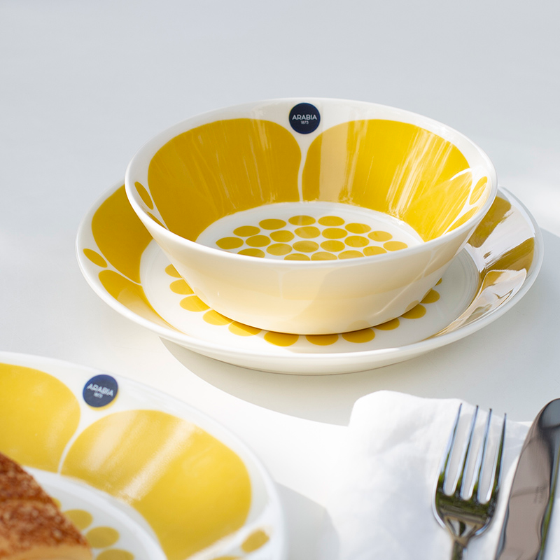 Round ceramic bowl dotted like sunlight through lace, with a bold petal motif