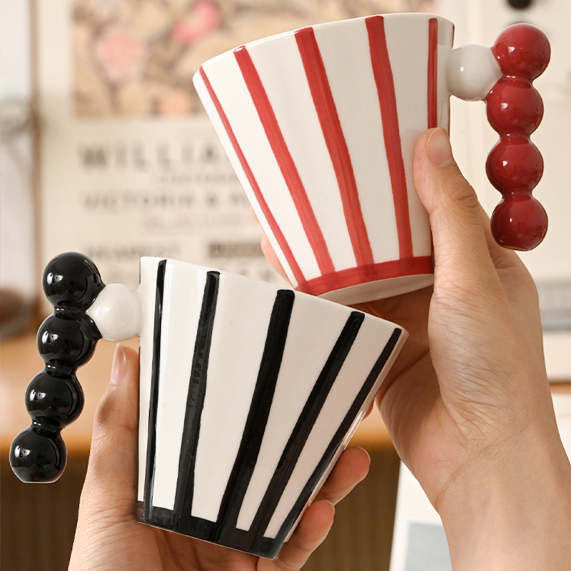 Bold striped ceramic mug with a sculptural bubble handle